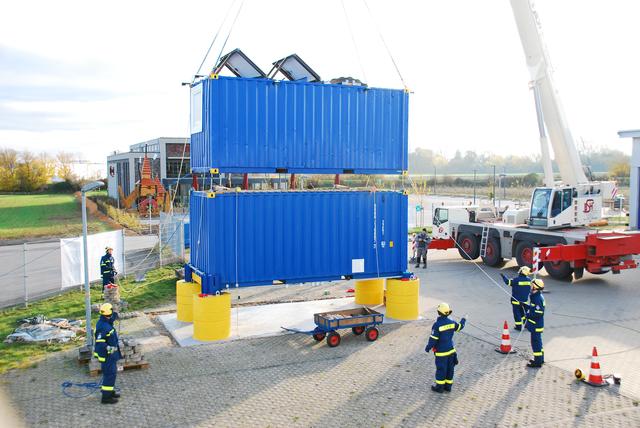THW Einsatzkräfte beim Aufstellen des Multifunktionscontainers.