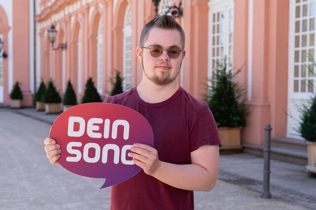Leben mit Einschränkung - das ist ein cooler Song über Behinderung von Lucas Löffelmann. Der singt:
Hey, ihr da draußen, wisst ihr wie das ist, wenn man anders als die ander'n ist? Ich bin cool und nicht immer brav - ich bin Jugendlicher mit För-der-be-darf!
Damit hat es der 18-jährige Kölner bis ins Halbfinale von "Dein Song" auf KIKA geschafft. Lucas hat das Downsyndrom. Er sagt: "Manchmal ist das Leben für mich schwieriger als andere Leute das haben." Von seinem Traum hält ihn das nicht ab: Lucas will Musiker werden.